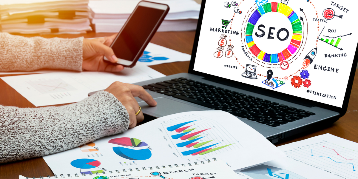 SEO on a computer screen surrounded by charts and graphs. 