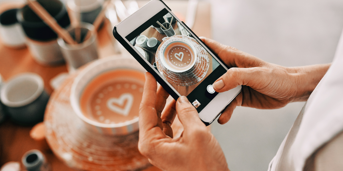 A picture is being taken of a coffee with a heart shaped design.